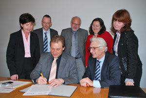 Gruppe von Personen unterzeichnet Dokument.