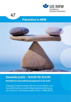 Das Bild zeigt eine Broschüre der Unfallkasse NRW mit dem Titel 'Prävention in NRW'. Zu sehen sind zwei Steine in Balance auf einem Holzstab. Der Text lautet 'Gesunde Justiz – Schritt für Schritt: Betriebliches Gesundheitsmanagement in der Justiz'. Es geht um die Integration psychosozialer Faktoren in den Arbeits- und Gesundheitsschutz sowie die Organisationsentwicklung von Gerichten und Staatsanwaltschaften in NRW (IPSO).