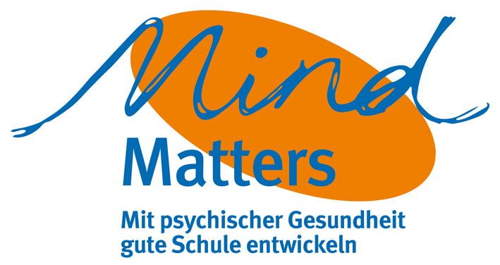 Das Bild zeigt das Logo von MindMatters. Das Wort 'Mind' ist in blauer, schwungvoller Schrift über einem orangefarbenen Oval geschrieben. Darunter steht 'Matters' in blauer Schrift. Darunter folgt der Slogan: 'Mit psychischer Gesundheit gute Schule entwickeln'. MindMatters ist ein Programm zur Förderung des Wohlbefindens an Schulen, passend im Kontext von Arbeitsschutz und Prävention für die Unfallkasse NRW.