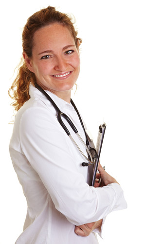 Eine lächelnde Frau trägt einen weißen Laborkittel und hat ein Stethoskop um den Hals. Sie hält einen Klemmbrett-Ordner in ihren Armen. Der Hintergrund ist weiß. Diese Darstellung könnte im Kontext von Arbeitsschutz und Prävention im Gesundheitswesen stehen, z.B. durch die Unfallkasse NRW unterstützt.