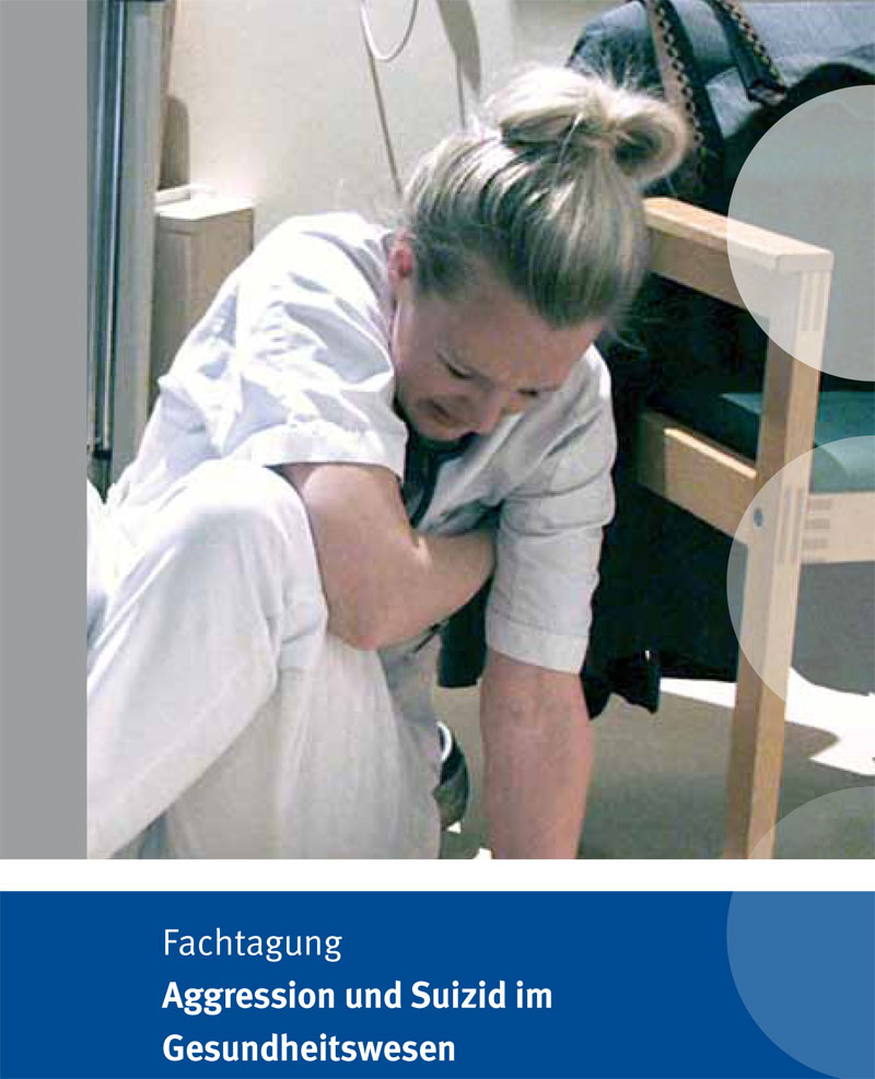Eine Krankenschwester in weißer Berufskleidung sitzt auf dem Boden eines Krankenhauses und hält sich den Arm, offenbar vor Schmerz gekrümmt. Daneben ist ein Stuhl zu sehen. Im unteren Bereich des Bildes befindet sich ein blauer Balken mit der Aufschrift 'Fachtagung Aggression und Suizid im Gesundheitswesen'. Dieses Thema ist relevant für Arbeitsschutz und Prävention im Gesundheitssektor.