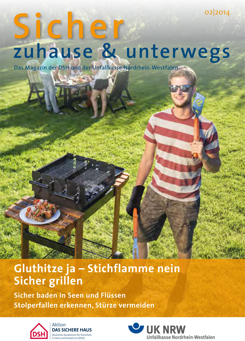 Ein Mann mit Sonnenbrille, T-Shirt und Shorts steht lächelnd vor einem Holzkohlegrill im Garten. Er hält Grillzange und Grillwender in der Hand. Auf dem Grill brennen Kohlen gleichmäßig. Im Hintergrund sitzen zwei weitere Personen unter einem Sonnenschirm. Auf dem Bild stehen die Texte: 'Sicher zuhause & unterwegs', 'Glut hitze ja – Stichflamme nein', 'Sicher grillen', 'Unfallkasse Nordrhein-Westfalen'. Das Thema des Bildes bezieht sich auf Arbeitsschutz, Prävention und Sicherheitstipps im Haushalt oder beim Grillen im Freien im Zusammenhang mit der Unfallkasse NRW.
