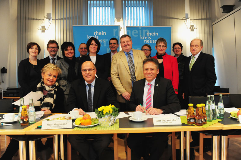 Das Bild zeigt Landrat Hans-Jürgen Petrauschke (sitzend, rechts) mit den Förderern und Partnern des Projekts "aufgeweckt" bei der Unterzeichnung der Rahmenvereinbarung.