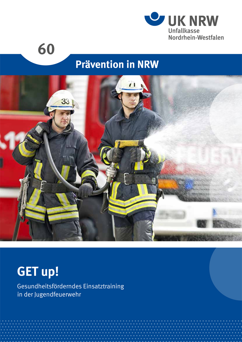 Zwei Feuerwehrleute in Schutzkleidung führen ein Wassereinsatztraining durch. Einer hält einen Schlauch, aus dem Wasser spritzt, während der andere in die Ferne schaut. Im Hintergrund ist ein rotes Feuerwehrfahrzeug zu sehen. Das Bild ist Teil einer Kampagne der Unfallkasse Nordrhein-Westfalen zur Prävention und fördernden Ausbildung in der Jugendfeuerwehr.