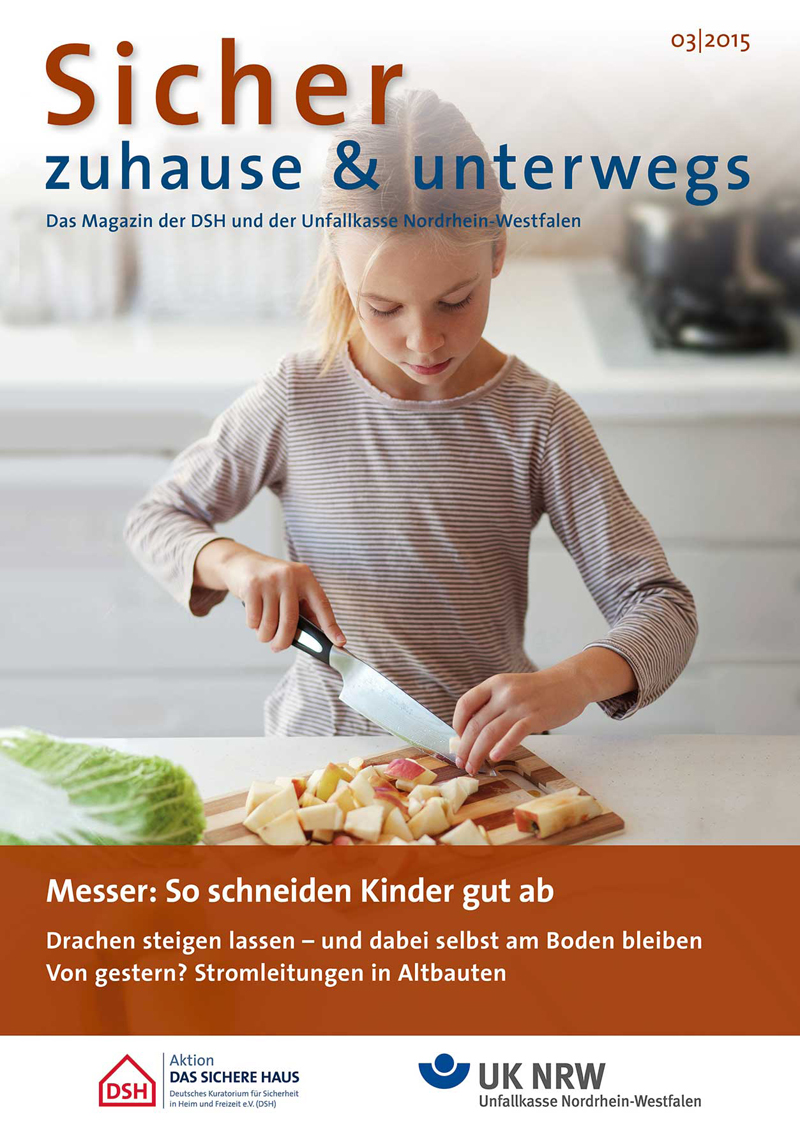 Ein junges Mädchen steht in einer Küche und schneidet mit einem Messer Brot auf einem Schneidebrett. Die Szene vermittelt einen Fokus auf Sicherheit und Aufsicht im häuslichen Umfeld, ein wichtiges Thema der Unfallkasse NRW im Rahmen von Arbeitsschutz und Prävention. Oben sind der Titel des Magazins 'Sicher zuhause & unterwegs' sowie das Logo der Unfallkasse Nordrhein-Westfalen zu sehen.