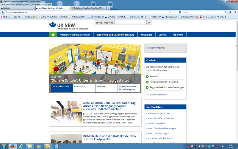 Screenshot der Website der Unfallkasse Nordrhein-Westfalen. Im Hauptbereich befindet sich ein Artikel über die Neugestaltung eines Unterrichtsraums unter dem Titel 'Sichere Schule'. Oben sind Navigationslinks wie Startseite, Versicherte und Leistungen, und Sicherheit und Gesundheitsschutz. Rechts befindet sich ein Kontaktbereich mit Informationen zu den Ansprechpartnern der UK NRW. Die Seite ist farblich in Blau und Weiß gestaltet, mit einem Bild eines Klassenzimmers, in dem Schüler und Lehrer interagieren. Kontext der Website: Arbeitsschutz und Prävention für Schulen in NRW.