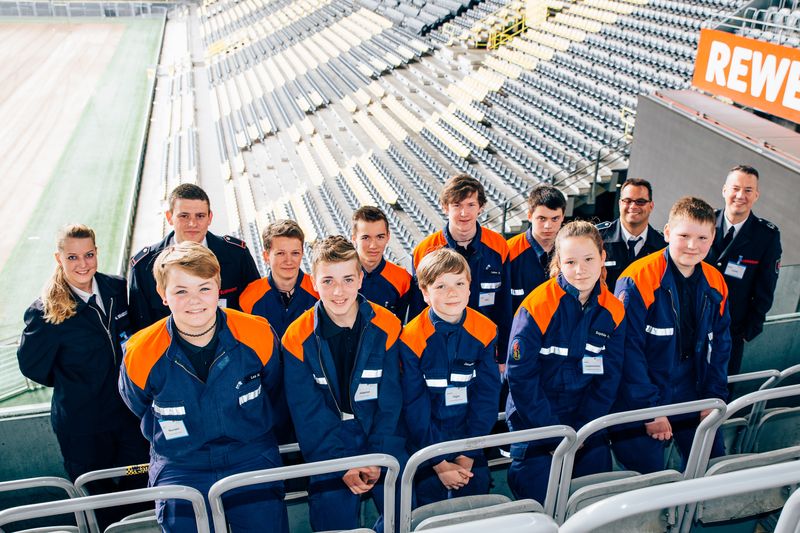 Jugendliche in Schutzkleidung in einem Stadion.
