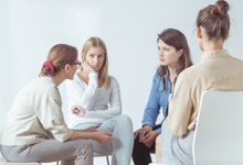 Vier Frauen in einem Gespräch im Büro.