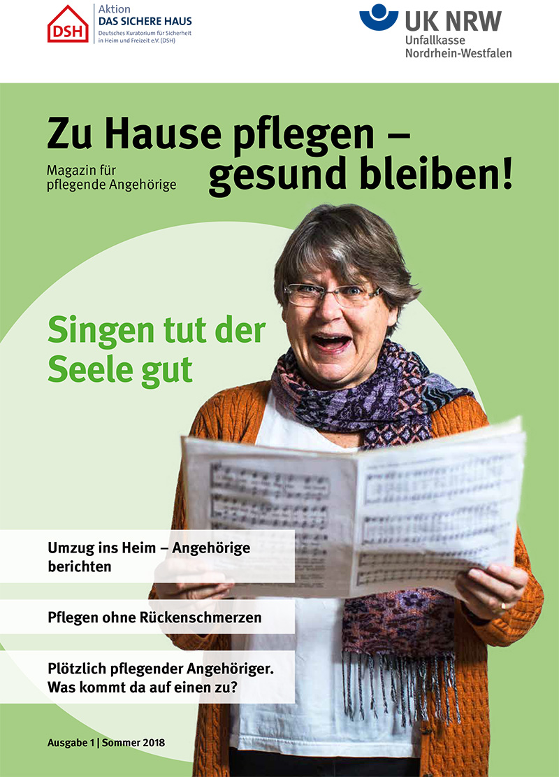 Eine ältere Frau mit Brille hält ein Blatt in der Hand und schaut erfreut darauf. Im Hintergrund sind das Logo der Unfallkasse Nordrhein-Westfalen und der Schriftzug 'Zu Hause pflegen – gesund bleiben! Singen tut der Seele gut' zu sehen. Weitere Textinhalte beinhalten Schlagzeilen wie 'Umzug ins Heim – Angehörige berichten', 'Pflegen ohne Rückenschmerzen' und 'Plötzlich pflegender Angehöriger. Was kommt da auf einen zu?'. Das Bild gehört zur Ausgabe 1|Sommer 2018 und richtet sich an pflegende Angehörige im Kontext von Arbeitsschutz und Prävention.