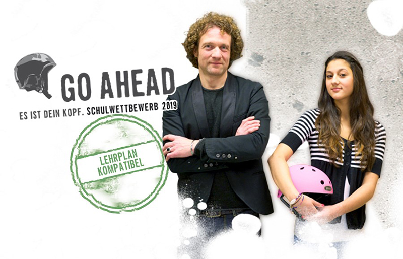 Das Bild zeigt zwei Personen, einen Mann und eine Frau, die nebeneinander stehen. Der Mann trägt ein schwarzes Outfit, die Frau hält einen rosa Helm in der Hand. Oben links ist das Logo eines Helms und der Text 'Go Ahead - Es ist dein Kopf. Schulwettbewerb 2019' zu sehen. Mittig ist ein grüner Stempel mit der Aufschrift 'Lehrplan kompatibel'. Der Hintergrund ist hell mit Spritzmustern. Das Bild bezieht sich auf einen Schulwettbewerb zu Arbeitsschutz und Prävention der Unfallkasse NRW.