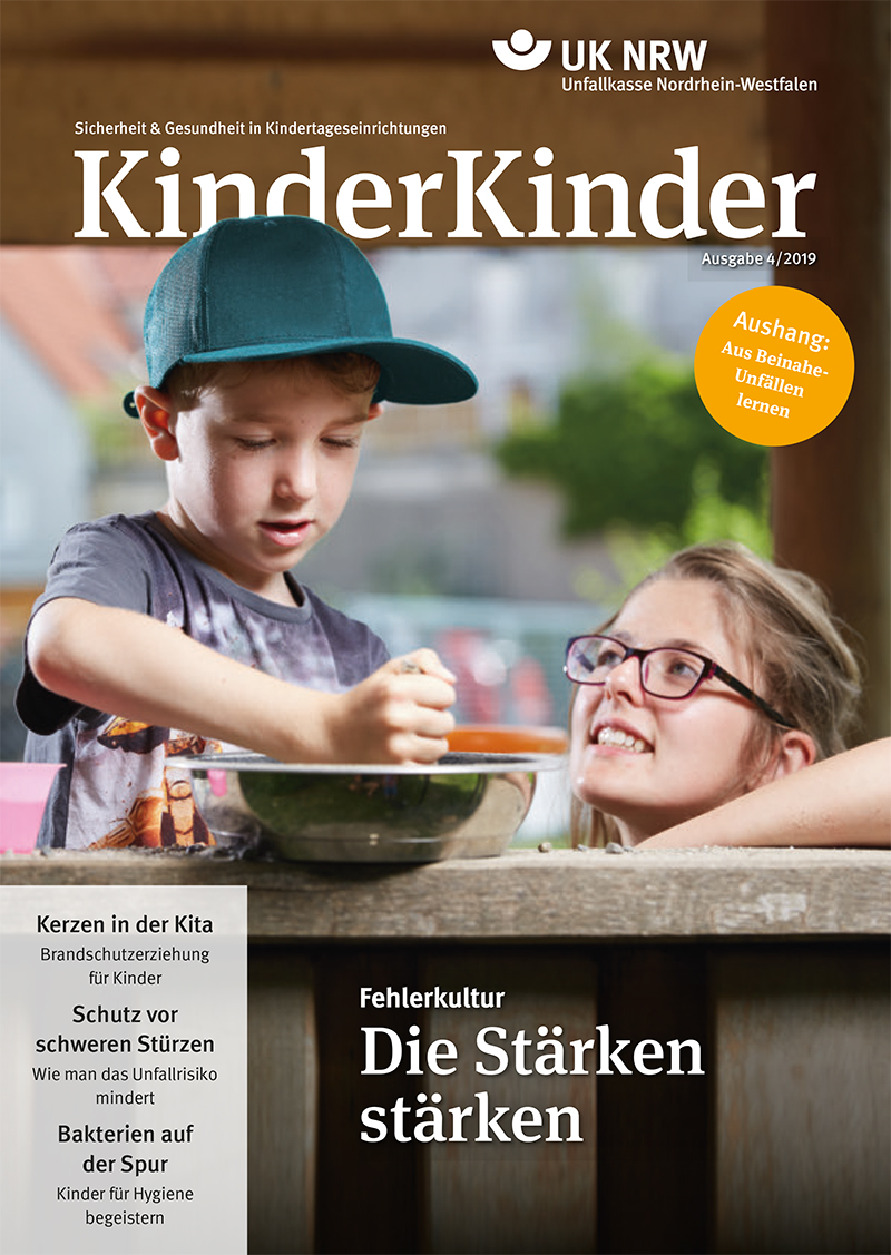 Das Titelbild der Zeitschrift KinderKinder der Unfallkasse Nordrhein-Westfalen zeigt zwei Kinder beim gemeinsamen Backen. Ein Kind gießt eine Flüssigkeit in eine Schüssel, das andere schaut zu. Oben steht 'Sicherheit & Gesundheit in Kindertageseinrichtungen'. Themen sind Brandschutz, Schutz vor Stürzen und Unfallvermeidung. Ziel ist der Arbeitsschutz und die Prävention in Kindergärten.