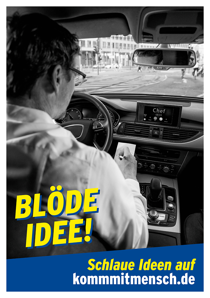 Ein Mann sitzt am Steuer eines Autos und schreibt während der Fahrt auf einem Notizblock. Im Hintergrund ist eine Stadtstraße zu sehen. Auf dem Bildschirm des Autos steht 'Chef'. Der Text 'BLÖDE IDEE!' ist auffällig in Gelb auf Blau geschrieben, darunter in Weiß 'Schlaue Ideen auf kommtimensch.de', einem Hinweis der Unfallkasse NRW auf Arbeitsschutzmaßnahmen.