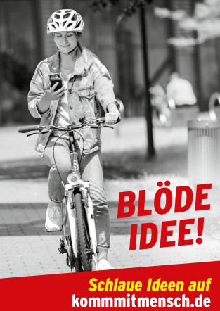 Eine Frau fährt auf einem Fahrrad und schaut auf ihr Handy. Sie trägt einen Fahrradhelm und eine Jeansjacke. Der Hintergrund zeigt eine unscharfe städtische Umgebung. Unten im Bild steht in roter Schrift 'Blöde Idee!' und darunter 'Schlaue Ideen auf kommmitmensch.de'. Die Darstellung warnt vor den Gefahren der Ablenkung im Straßenverkehr und fördert Arbeitsschutz und Prävention im Kontext der Unfallkasse NRW.