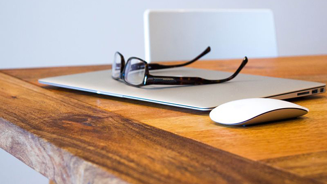 Das Bild zeigt einen Schreibtisch auf dem eine Brille liegt