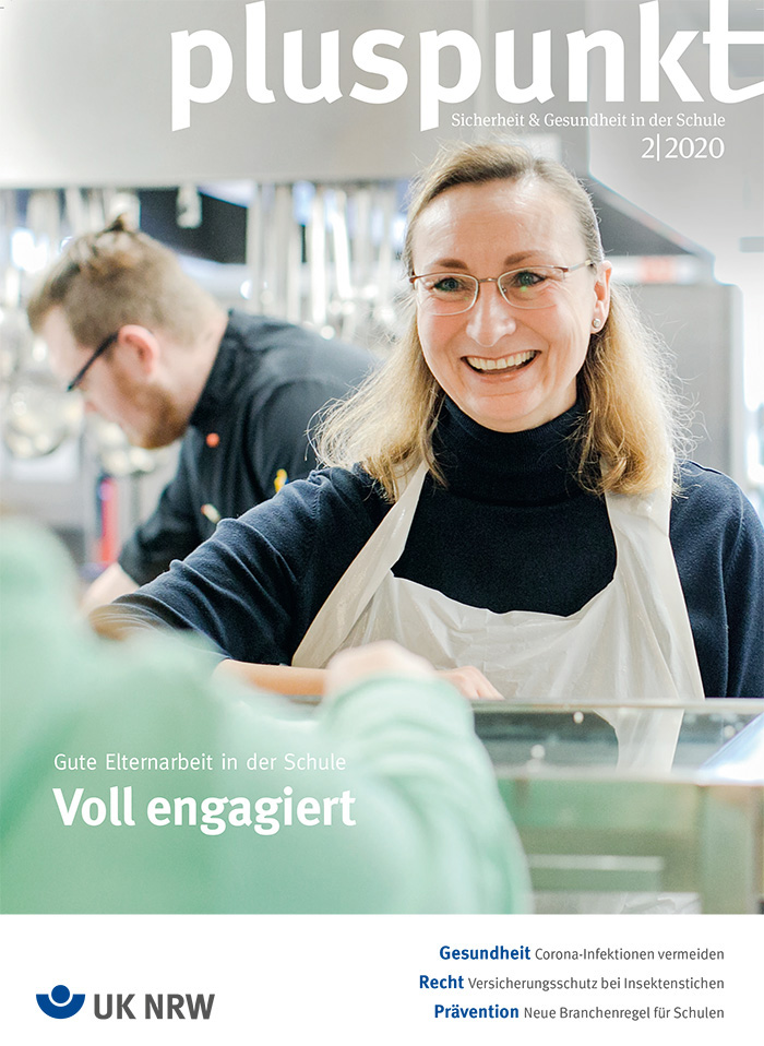 Eine Lehrerin trägt eine Schürze und lächelt, während sie in einer Schulküche arbeitet. Im Hintergrund sind Schüler, die ebenfalls aktiv in der Küche tätig sind. Der Kontext der Unfallkasse NRW betont die Bedeutung von Arbeitsschutz und Prävention in der Schule. Text auf dem Bild: 'pluspunkt - Sicherheit & Gesundheit in der Schule 02/2020', 'Gute Elternarbeit in der Schule', 'Voll engagiert'.
