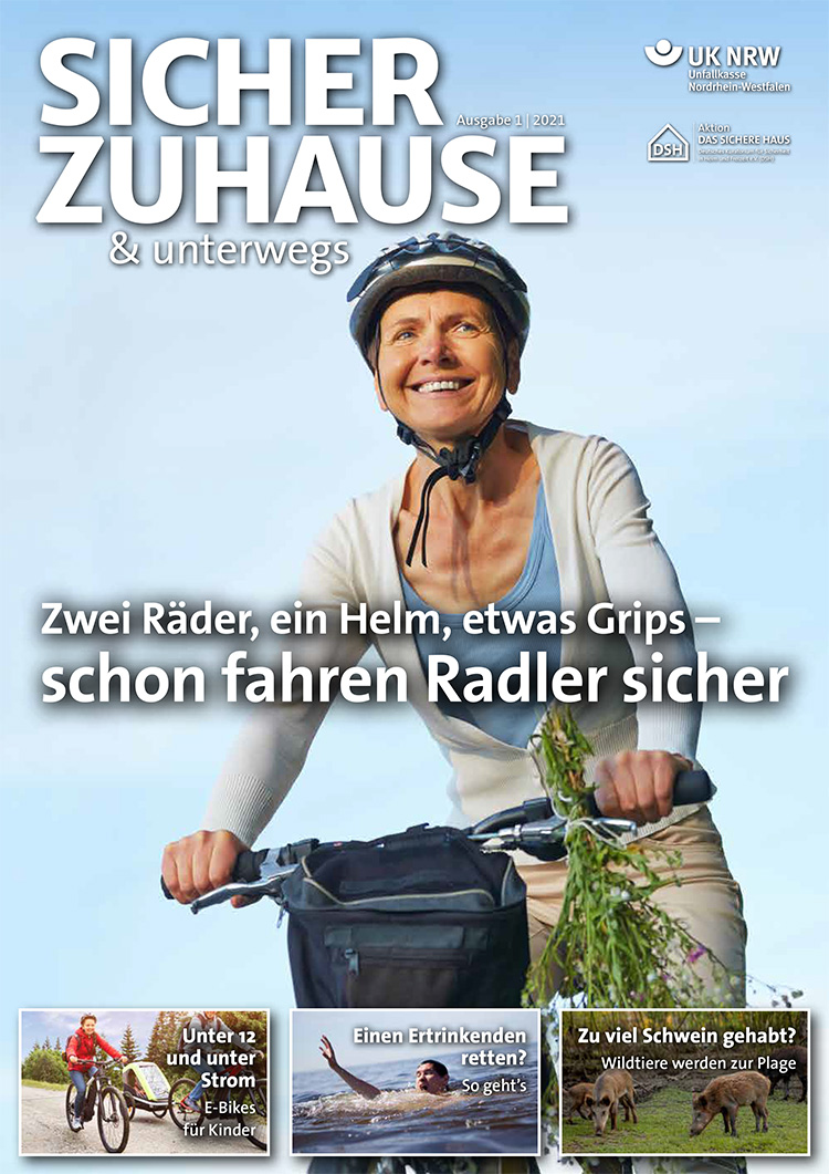 Eine Frau trägt einen Fahrradhelm und fährt auf einem Fahrrad. Sie hält frisches Gemüse in einem Korb auf dem Fahrrad und lächelt fröhlich. Im Hintergrund ist blauer Himmel. Oben steht der Schriftzug 'SICHER ZUHAUSE & unterwegs'. Unter dem Bild steht: 'Zwei Räder, ein Helm, etwas Grips – schon fahren Radler sicher'. Das Bild gehört zur Veröffentlichung der Unfallkasse NRW, die sich mit Arbeitsschutz und Prävention befasst.