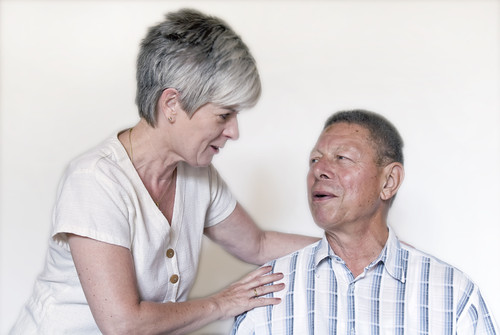 Zwei Menschen im Gespräch; eine Frau legt einem Mann die Hand auf die Schulter.