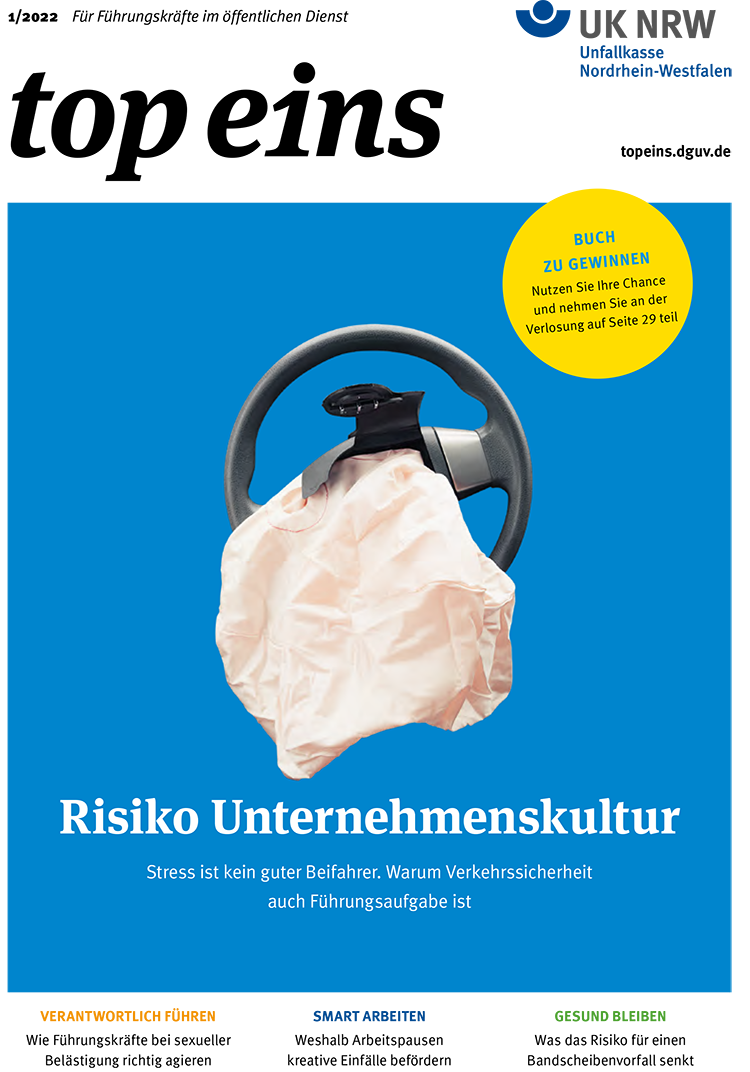 Ein Plakat zeigt ein Lenkrad mit aufgeblasenem Airbag auf einem blauen Hintergrund. Rechts oben ist ein gelber Kreis mit der Aufschrift: 'Buch zu gewinnen. Nutzen Sie Ihre Chance und nehmen Sie an der Verlosung auf Seite 29 teil'. Darunter steht: 'Risiko Unternehmenskultur. Stress ist kein guter Beifahrer. Warum Verkehrssicherheit auch Führungsaufgabe ist'. Das Plakat thematisiert Arbeitsschutz und Prävention im Kontext der Verkehrssicherheit und stressfreien Unternehmenskultur, im Zusammenhang mit der Unfallkasse NRW.