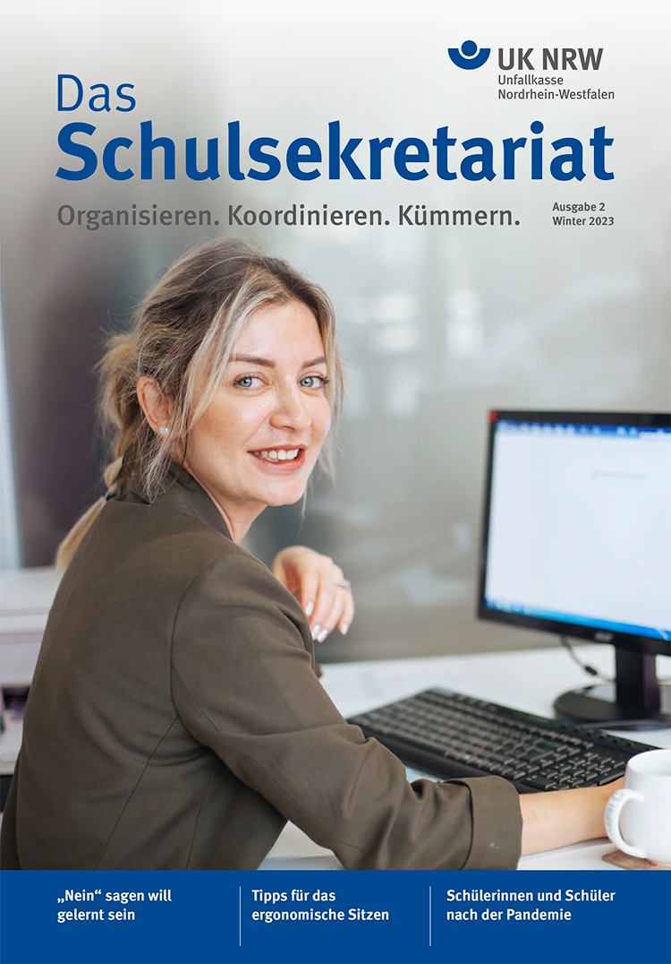 Eine Frau sitzt an einem Schreibtisch vor einem Computerbildschirm und lächelt in die Kamera. Oben links steht der Titel 'Das Schulsekretariat', darunter der Untertitel 'Organisieren. Koordinieren. Kümmern.' Oben rechts befindet sich das Logo der Unfallkasse Nordrhein-Westfalen (UK NRW) und der Hinweis 'Ausgabe 2 Winter 2023'. Unten auf dem Cover sind drei Themen aufgelistet: 'Nein sagen will gelernt sein', 'Tipps für das ergonomische Sitzen', und 'Schülerinnen und Schüler nach der Pandemie'.