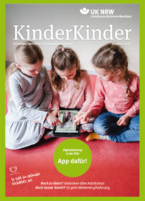Auf dem Bild sitzen drei junge Kinder auf einem roten Teppich in einem Kindergarten. Zwei Mädchen und ein Junge schauen gemeinsam auf ein Tablet und interagieren damit. Alle Kinder wirken konzentriert und interessiert. Oben links im Bild ist das Logo der Unfallkasse Nordrhein-Westfalen mit dem Text 'UK NRW' zu sehen, sowie der Titel der Zeitschrift 'KinderKinder' und der Untertitel 'Sicherheit & Gesundheit in Kindertageseinrichtungen'. Das Bild illustriert das Thema 'Digitalisierung in der Kita' und zeigt, wie technologische Geräte in Bildungseinrichtungen genutzt werden können.