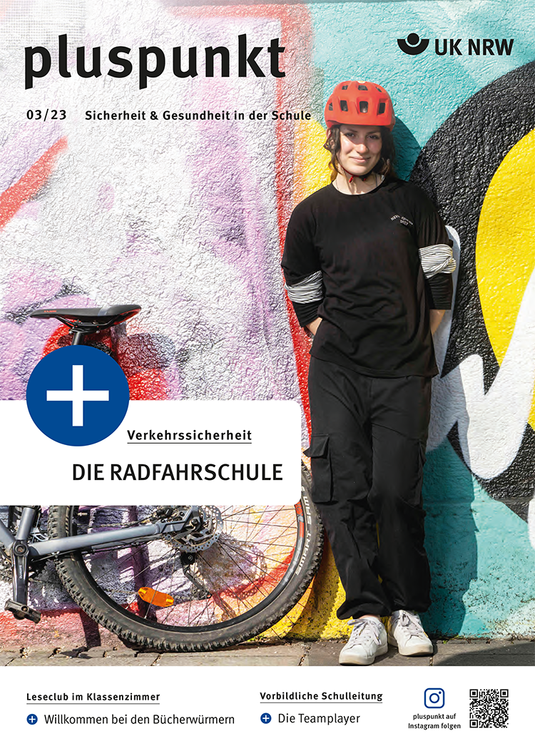 Eine Frau trägt einen roten Fahrradhelm und schwarze Kleidung. Sie lehnt lächelnd an einer bunten Graffiti-Wand. Neben ihr steht ein weißes Fahrrad mit Korb. Oben steht 'pluspunkt 03/23 Sicherheit & Gesundheit in der Schule'. Das Thema 'Die Radfahrschule' wird hervorgehoben. Die Broschüre ist von der Unfallkasse NRW, mit Fokus auf Arbeitsschutz und Prävention. Auf der linken Seite sind weitere Themen erwähnt: 'Willkommen bei den Bücherwürmern' und 'Vorbildliche Schulleitung'.