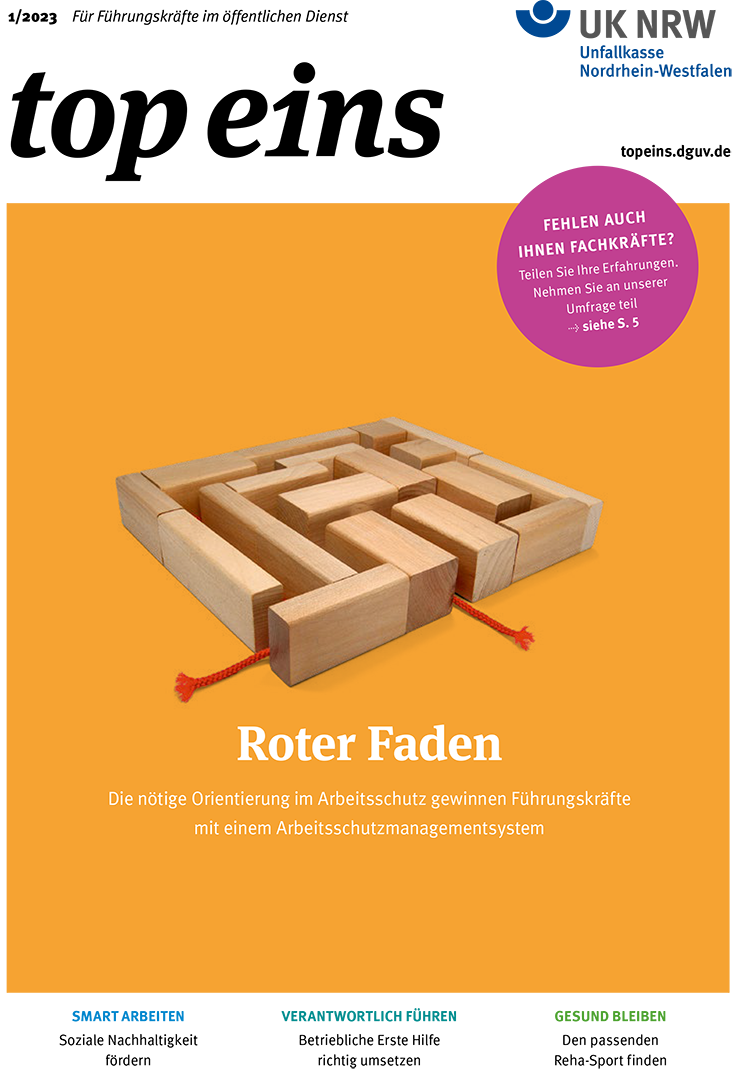 Das Bild zeigt ein Holzlabyrinth auf einem orangefarbenen Hintergrund. Oben rechts befindet sich ein pinker Kreis mit der Aufschrift: 'Fehlen auch Ihnen Fachkräfte? Teilen Sie ihre Erfahrungen. Nehmen Sie an unserer Umfrage teil. -> siehe S. 5'. Darunter steht in roter Schrift 'Roter Faden' und kleinerer weißer Schrift 'Die nötige Orientierung im Arbeitsschutz gewinnen Führungskräfte mit einem Arbeitsschutzmanagementsystem'. Das Bild thematisiert Arbeitsschutz und Prävention, relevant für die Unfallkasse NRW.