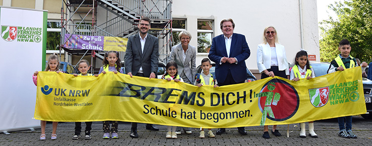 Michael Stock, Geschäftsführer der Unfallkasse NRW, Dorothee Feller, Schulministerin, Klaus Voussem, Präsident der Landesverkehrswacht NRW und Elke Lins, Dezernatsleiterin Prävention der Unfallkasse NRW präsentieren zusammen mit i-Dötzchen eines der Banner zum Schulanfang.
Foto: Landesverkehrswacht NRW