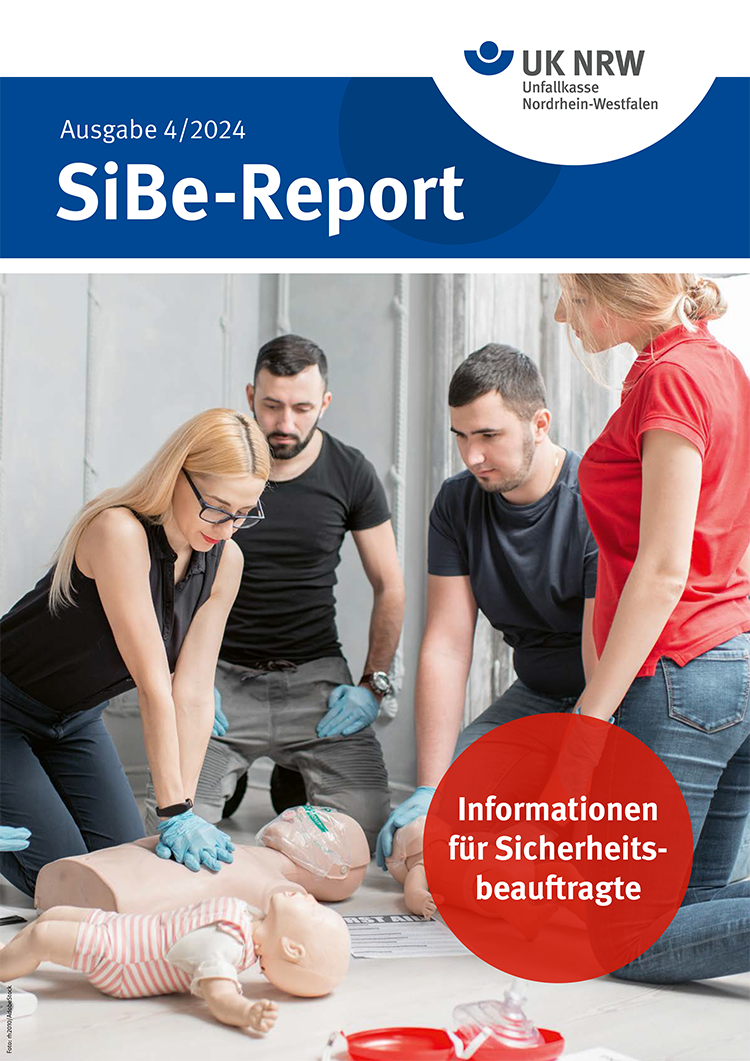 Vier Erwachsene, zwei Männer und zwei Frauen, üben auf einem Boden kniend an Säuglings- und Erwachsenen-Puppen Erste Hilfe. Sie tragen Freizeitkleidung. Im Kontext des SiBe-Reports der Unfallkasse NRW wird auf Arbeitsschutz und Prävention hingewiesen. Die Szene vermittelt Training zur Verbesserung der Sicherheit am Arbeitsplatz.