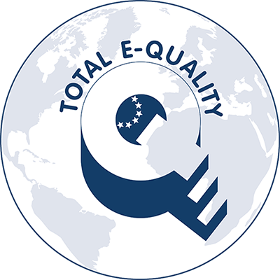 Das Logo von Total E-Quality zeigt stilisiert ein großes 'Q', das in den Globus integriert ist. Der Globus ist in helleren und dunkleren Blautönen gehalten. Im oberen Teil des 'Q' sind fünf Sterne eingefügt, die an einen Halbkreis erinnern. Um das Logo steht in Großbuchstaben 'TOTAL E-QUALITY'. Diese Darstellung steht für die Prinzipien der Chancengleichheit und Vielfalt. Der Kontext bezieht sich auf Arbeitsschutz sowie Präventionsmaßnahmen, die von der Unfallkasse NRW unterstützt werden.